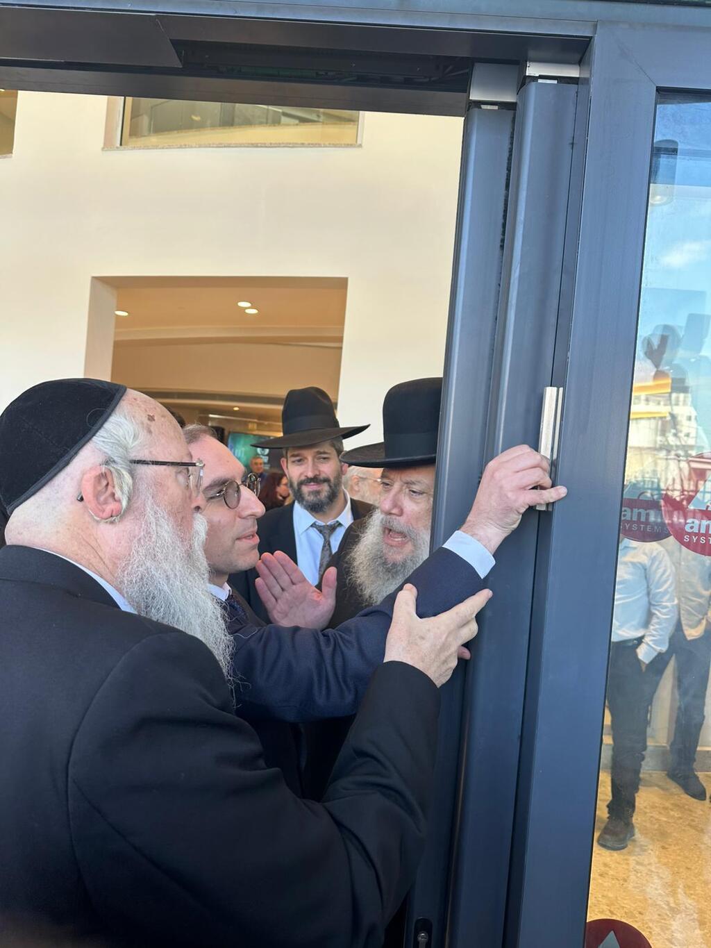 Rabbi Yehuda Marmorstein, center, affixes a mezuzah to the entrance of the rebuilt ALEH campus in Bnei Brak, Dec. 15, 2025 