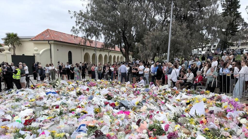 Mourning at the site of the antisemitic attack in Australia's Bondi Beach ( Photo: Hollie Adams/Reuters) זרי פרחים בזירת הפיגוע בחוף בונדיי בסידני