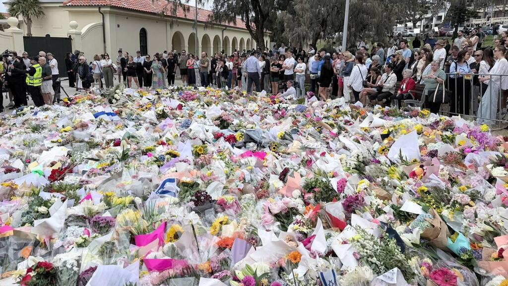 People gather at a makeshift memorial at the site of the Bondi Beach attack זרי פרחים בזירת הפיגוע בחוף בונדיי בסידני