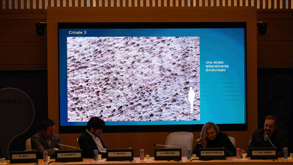 Paleontologist at Natural History Museum of Milan, Cristiano Dal Sasso, right, presents thousands of dinosaur footprints near aOlympic venue (Photo: Piero Cruciatti / AFP) Paleontologist at the Natural History Museum of Milan Cristiano Dal Sasso, right, comments on photos during press conference to present the discovery of thousands of dinosaur tracks discovered in Italy's Stelvio National Park near the areas that will host the Milano-Cortina 2026 Olympic Games, in Milan on December 16, 2025.