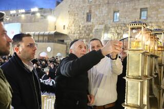 אביו של בנימין מדליק נרות חנוכה בכותל המערבי