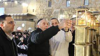 אביו של בנימין מדליק נרות חנוכה בכותל המערבי