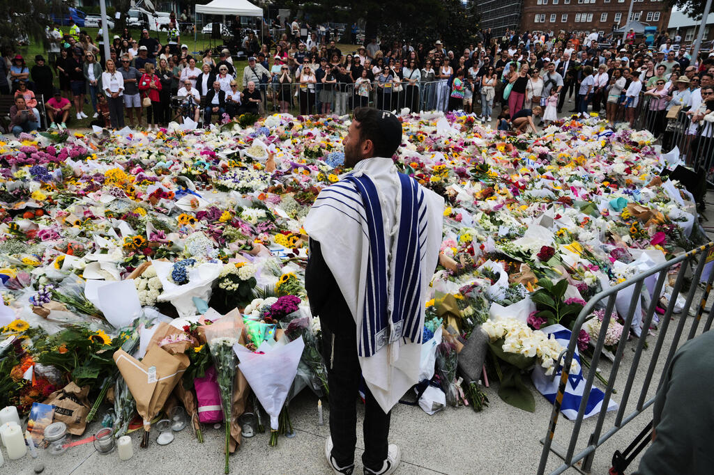 Visitors to the scene of the Bondi Beach massacre (Photo: Mark Baker/AP) אוסטרליה פיגוע טרור טבח חנוכה סידני פרחים ב זירת הפיגוע