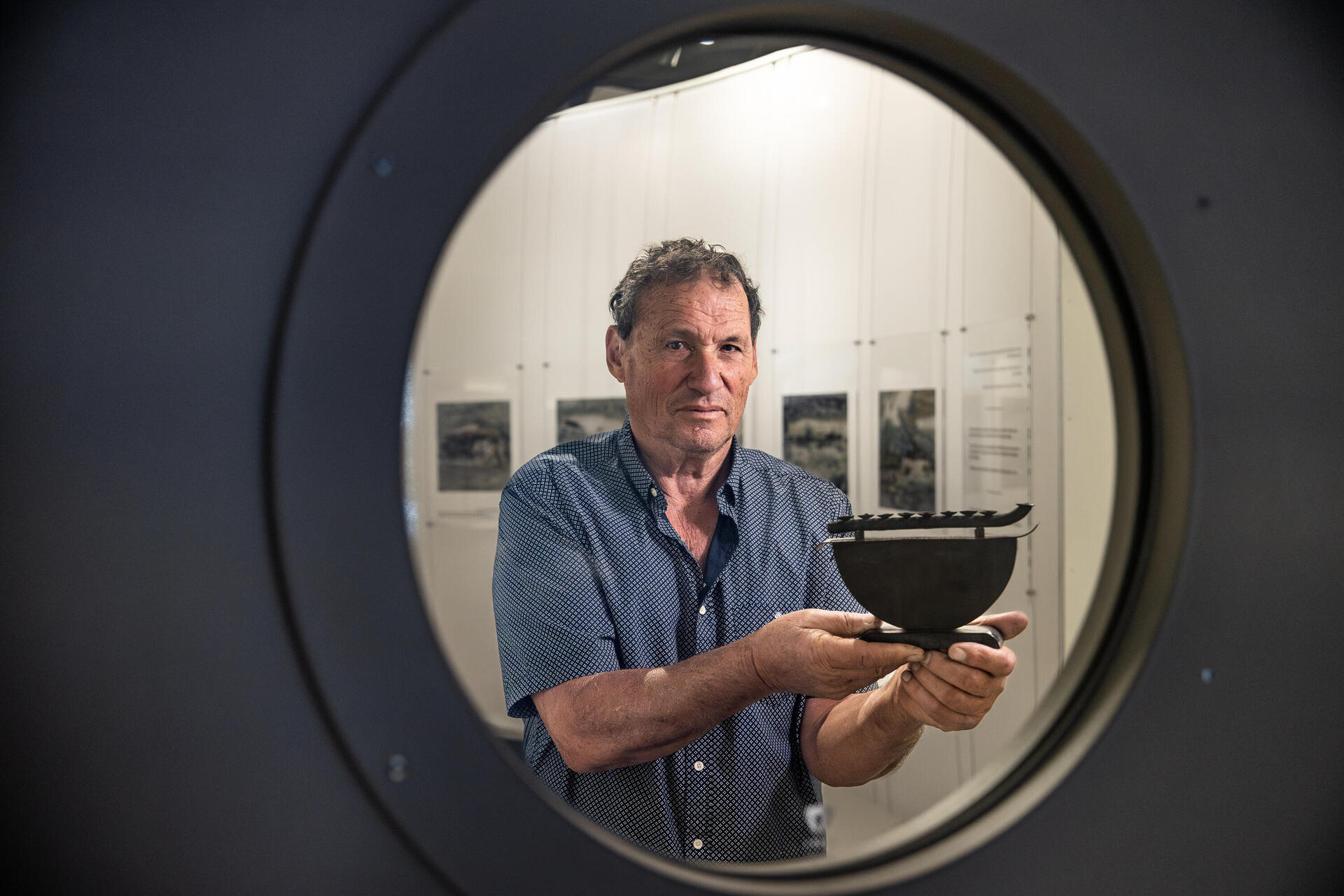 יהודה ליפמן עם חנוכייה שבנה אביו, שהשתמש בחלק מצוללת של הנאצים  