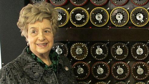 רות ברון משמאל ליד דגם של מכונת פענוח של האניגמה