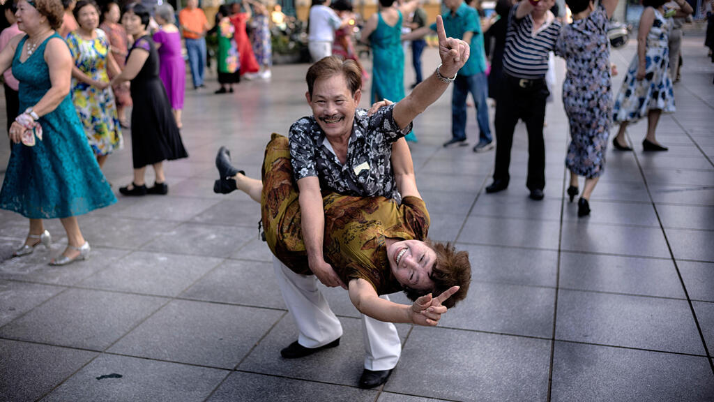 זוג וייטנאמי מתרגל ריקודי סלוניים כחלק משגרת אימון הבוקר שלו לאורך אגם הואן קיאם בהאנוי, וייטנאם, 2 במאי 2025