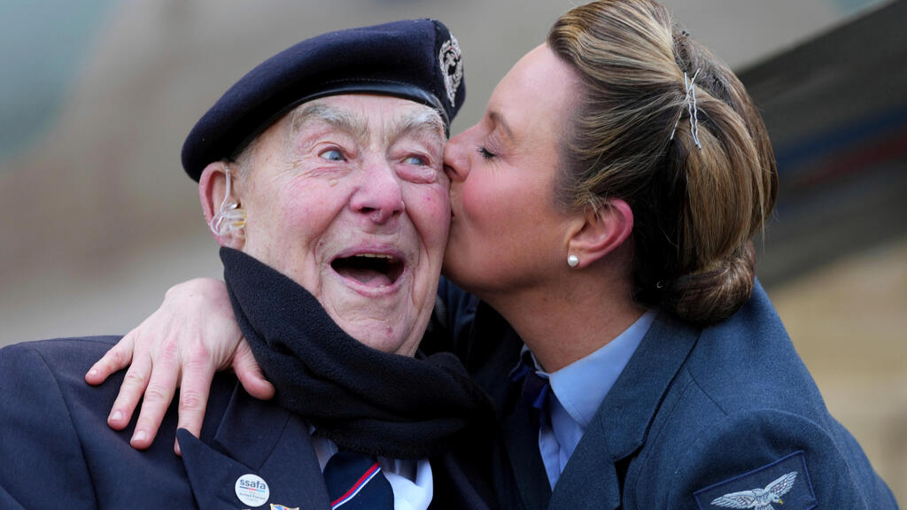 הנרי רייס, ותיק נורמנדי בן 98, מקבל נשיקה מקייטי אשבי, מייסדת והסולנית הראשית של להקת D-Day Darlings, עם פתיחת ספירת 80 הימים לקראת יום הניצחון באירופה (VE Day 80) ביוזמת SSAFA – עמותת הכוחות המזוינים הוותיקה ביותר בבריטניה – באולם רויאל אלברט הול בלונדון, 17 בפברואר 2025.
