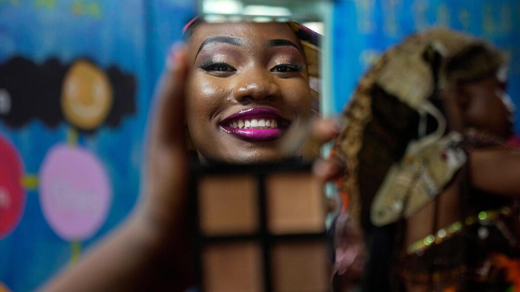 דוגמנית משתקפת במראה כשהיא מתאפרת במהלך תחרות המנהיגות מר ומיס קיברה, שנערכה ביום הנוער הבינלאומי, בניירובי, קניה, 12 באוגוסט 2025.