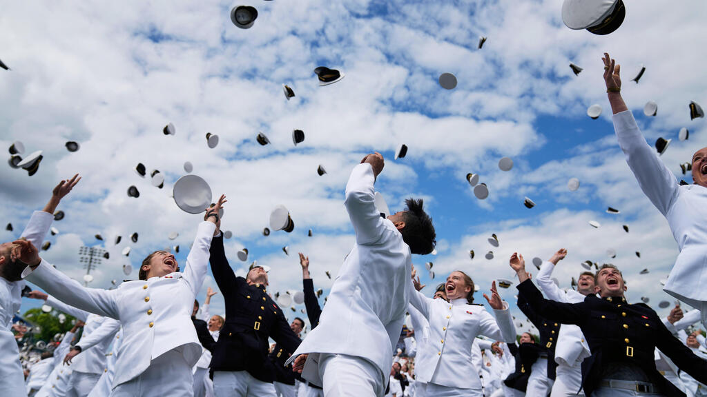 בוגרי האקדמיה הימית של ארצות הברית משליכים את כובעיהם לאוויר במהלך טקס הסיום וההסמכה של האקדמיה, באנאפוליס שבמדינת מרילנד, 23 במאי 2025.