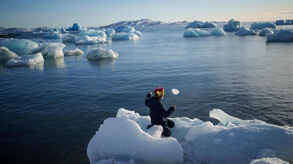 ילד משליך קרח אל הים בנוק, גרינלנד, 11 במרץ 2025.
