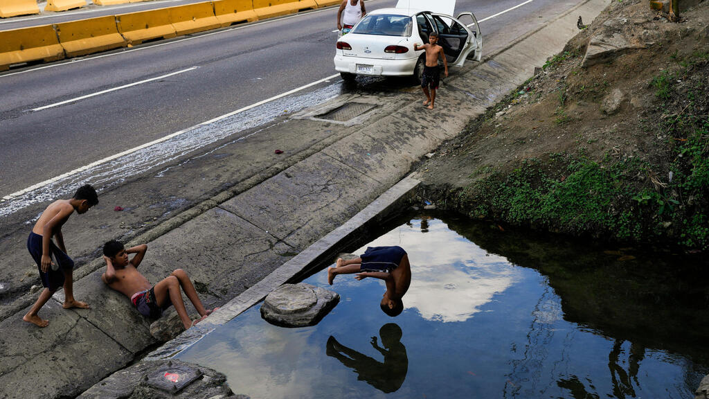 ילד קופץ בראש קדימה לתעלת ניקוז, יום לאחר השבעתו של נשיא ונצואלה ניקולס מדורו לכהונה שלישית, בקראקס, ונצואלה, 11 בינואר 2025.