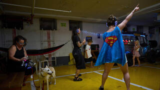 אנשים רוקדים במסיבת אוזניות בחניון תת-קרקעי המשמש מקלט מפני מתקפות טילים אפשריות מאיראן, בתל אביב, ישראל, 23 ביוני 2025