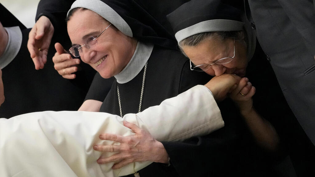 נזירה מנשקת את ידו של האפיפיור לאו ה-14 במהלך הקהל הכללי השבועי שלו, בוותיקן, 20 באוגוסט 2025.