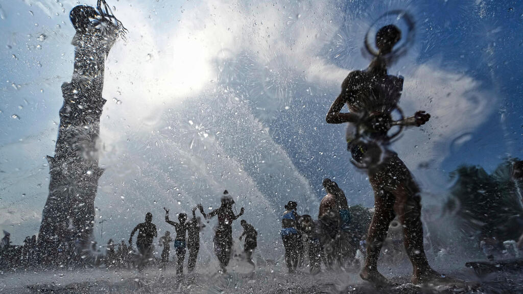 ילדים רצים בין סילוני מזרקת מים בסנט פטרסבורג, רוסיה, 12 ביולי 2025.
