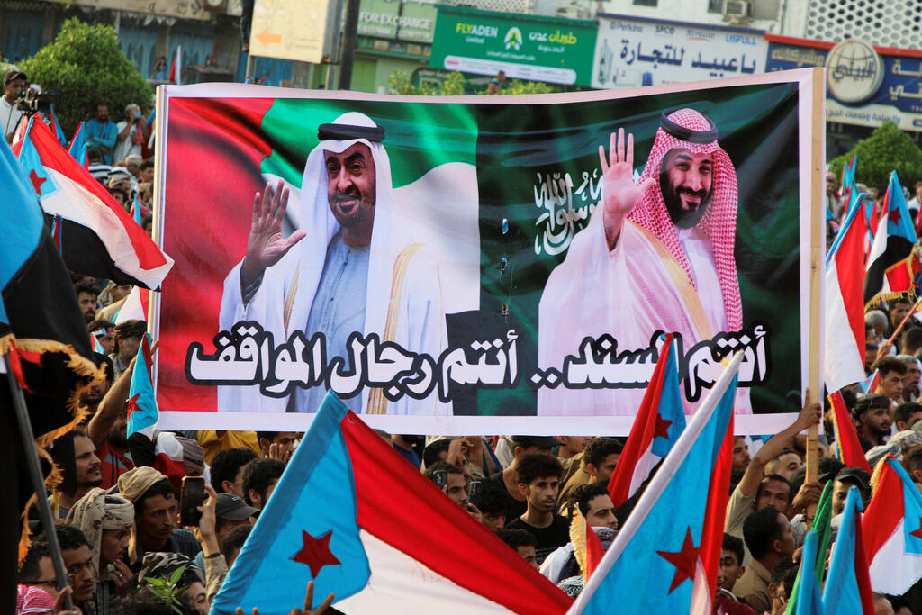People hold a banner with images of the President of the United Arab Emirates, Sheikh Mohamed bin Zayed Al Nahyan, and Crown Prince and Prime Minister Mohammed bin Salman of Saudi Arabia during a rally organised by Yemen's main separatist group, the Southern Transitional Council (STC), in Aden, Yemen December 21, 2025 