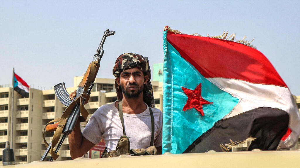 A fighter of the UAE-trained Security Belt Force, dominated by members of the Southern Transitional Council (STC) which seeks independence for south Yemen, poses with an AK-47 assault rifle and the southern separatist flag (the old flag of South Yemen), while standing in the back of a pickup truck in the Khor Maksar district of the second city of Aden on August 29, 2019 