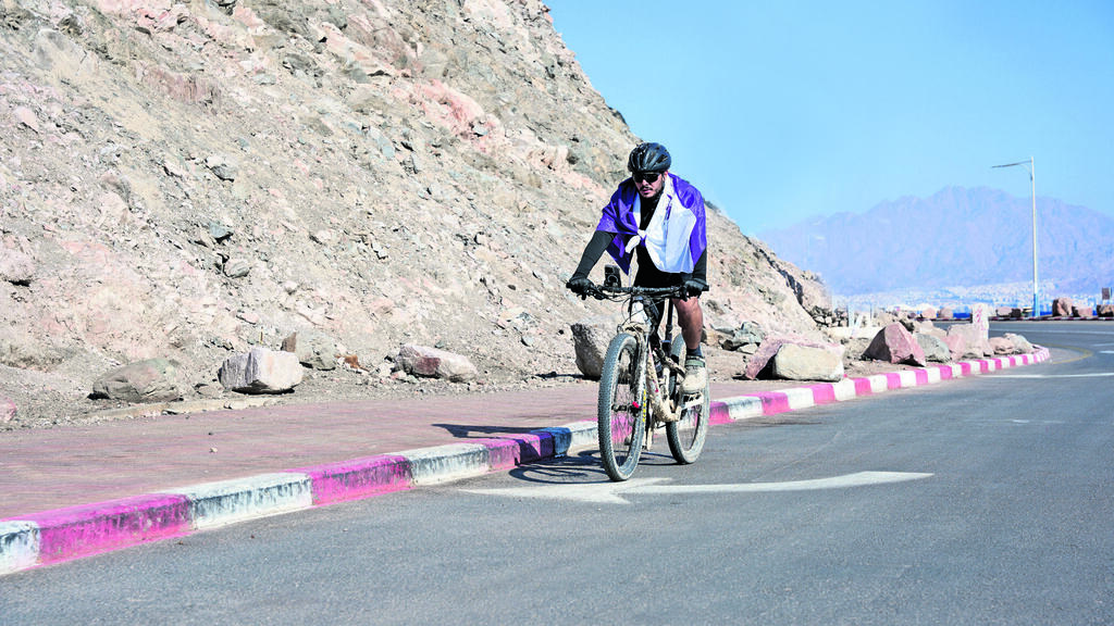 עומר בן עטיה על האופניים בדרך מאילת לטאבה, עם דגל סיירת גבעתי