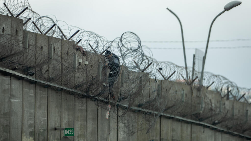 פלסטיני עובר את החומה באזור ירושלים