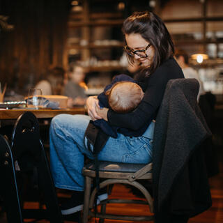 אישה מיניקה את בנה בבית קפה