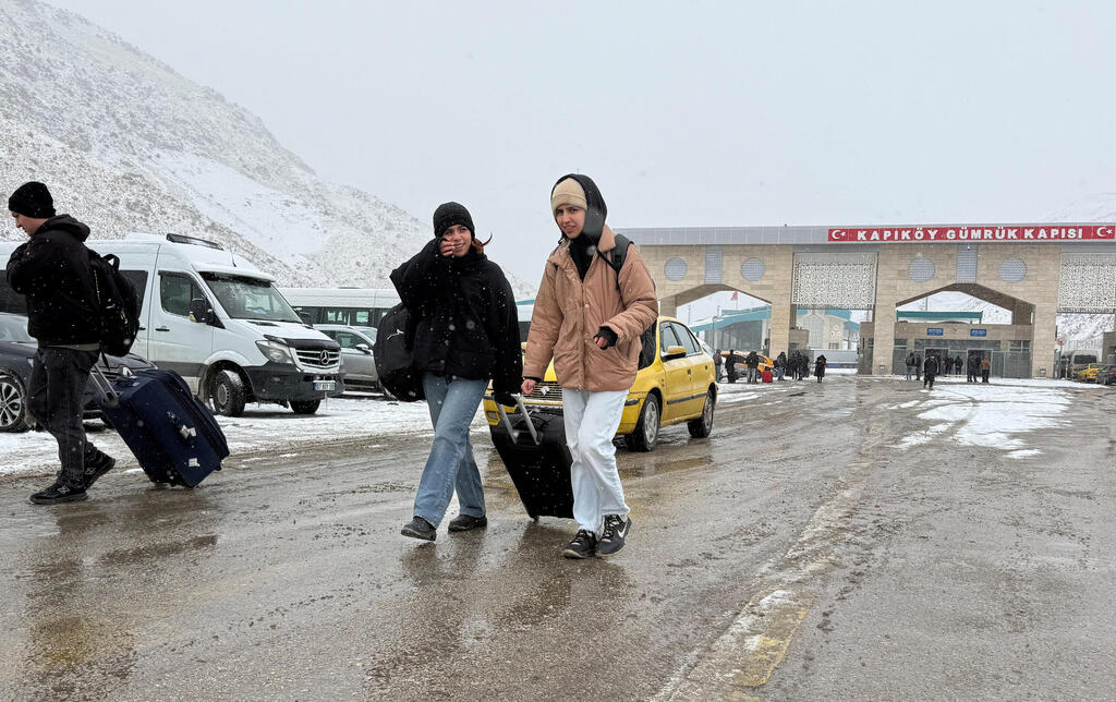 People make their way after crossing from Iran into Turkey at the Kapikoy Border Gate in eastern Van province, Turkey, January 15, 2026 