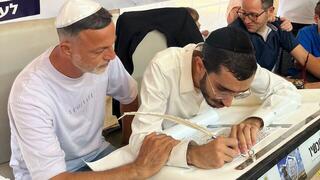 קובי סמרנו (משמאל) במעמד כתיבת אות בספר התורה לזכר בנו, יונתן ז"ל