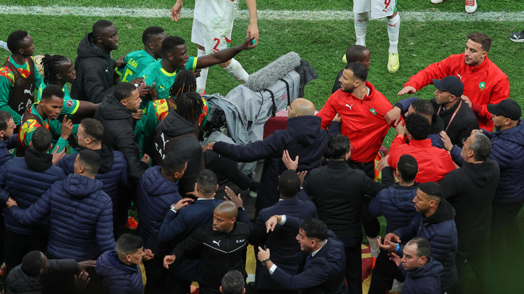 Security forces separate Morocco and Senegal players after the penalty whistle (Photo: Youssef Loulidi/ AP) כוחות אבטחה מפרידים בין שחקני מרוקו לסנגל ב גמר אליפות אפריקה
