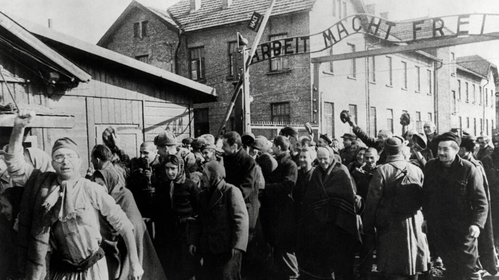 ניצולי מחנה הריכוז וההשמדה אושוויץ עוברים בשעריו עם שחרורו, פברואר 1945