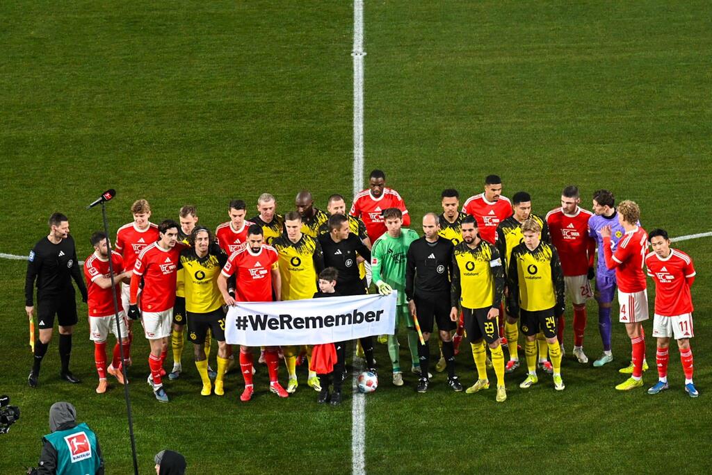 שחקני אוניון ברלין ודורטמונד עם השלט "אנחנו זוכרים"