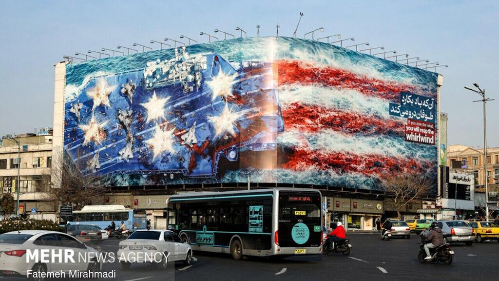 A ‘bleeding’ US flag and a bombarded aircraft carrier, the banner hung in Tehran השלטים שנתלו בטהרן