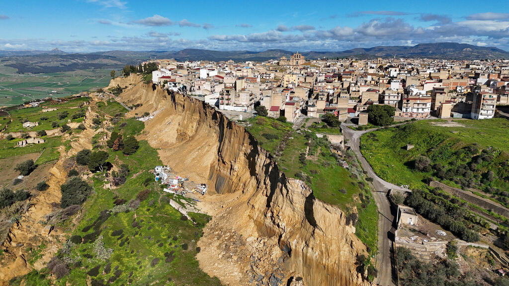 Homes hang precariously on the edge of a cliff in Niscemi, Sicily, after a landslide triggered by a severe storm (Photo: REUTERS/Danilo Arnone) איטליה בתים הידרדרו לסף תהום בעיירה נישמי ב סיציליה מפולת