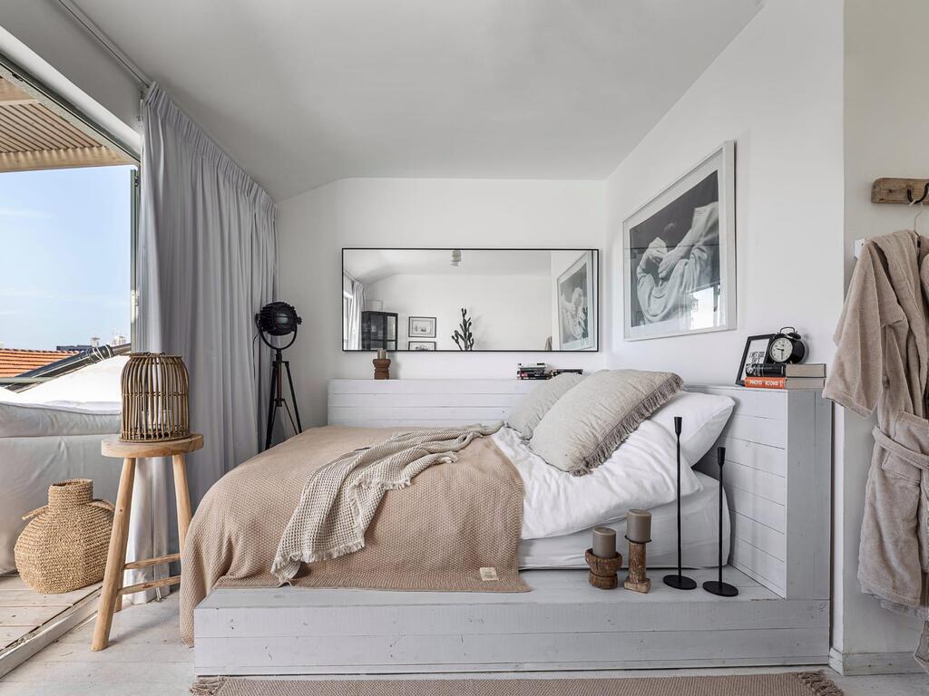 The bed is on a wooden platform and there is an exit to the balcony (Photo: Gadi Yosef) בית בנווה צדק, עיצוב: נעמה רודין אשר