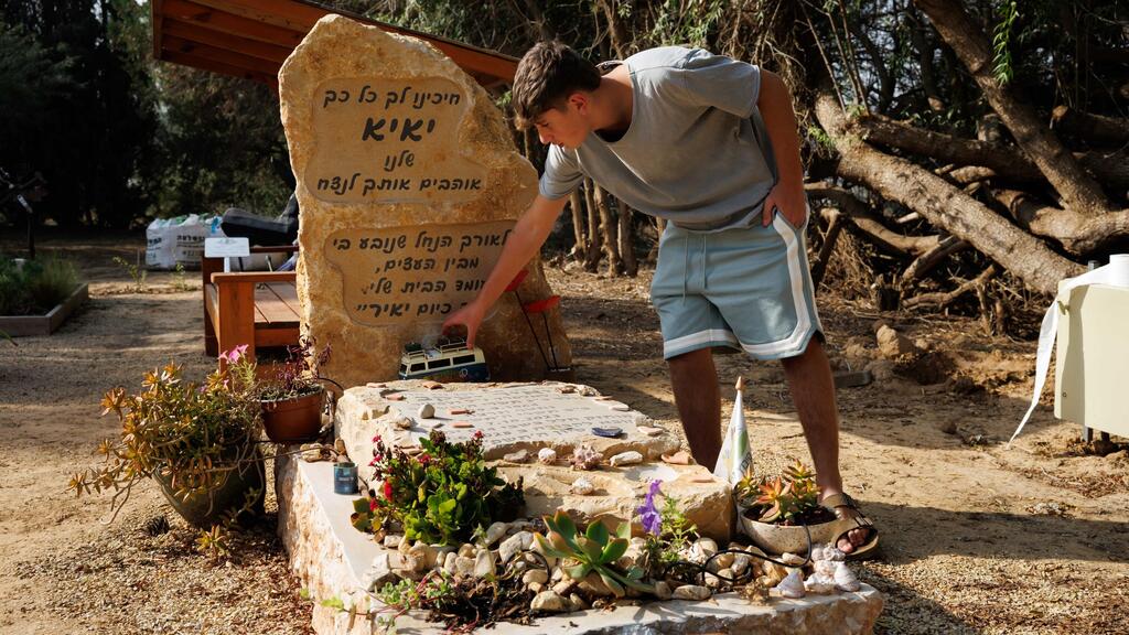 Yagil Yaakov next to his father's grave (Photo: Ziv Koren) יגיל יעקב, שורד השבי, חוזר לקיבוץ ניר עוז