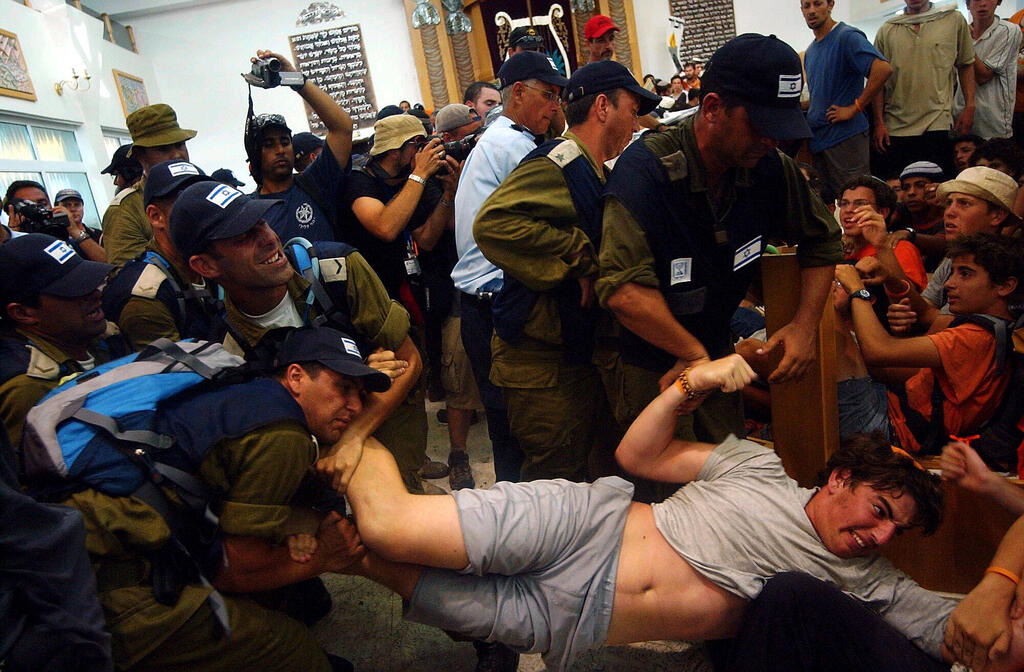 Israeli security forces remove Jewish residents and activists from a synagogue in the settlement of Neve Dekalim in the Gaza Strip during Israel's 2005 disengagement, which saw the evacuation of all Israeli settlements and military installations from Gaza (Photo: Alex Kolomoisky) פינוי בית הכנסת בנווה דקלים ב־2005