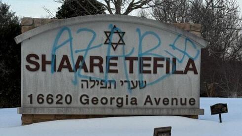 שלט של בית הכנסת שהושחת בצלב קרס