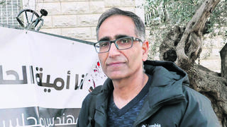 אומיה חוסיין מחוץ לביתו בדיר חנא