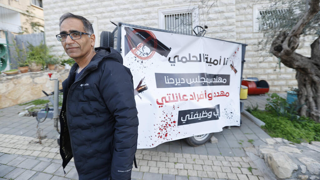 אומיה חוסיין מחוץ לביתו בדיר חנא