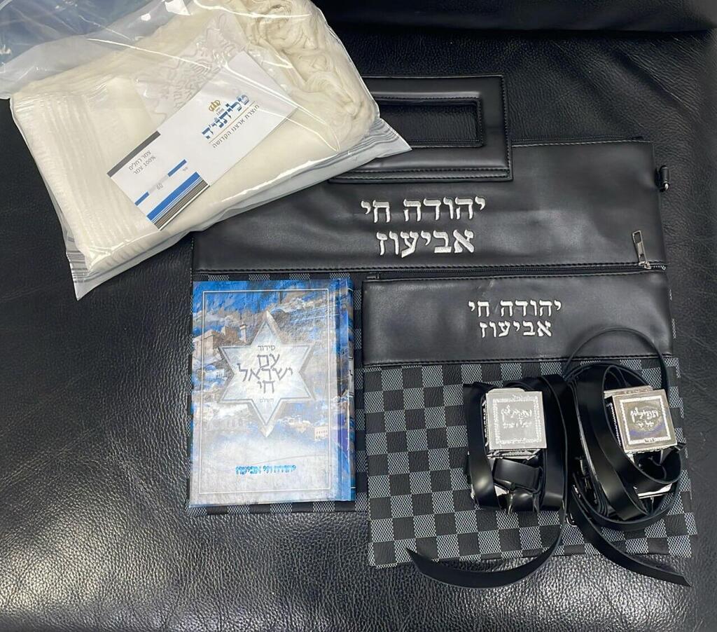The new tefillin and siddur presented to the police officer whose scooter was set on fire in Bnei Brak (Photo: Israel Police) התפילין החדשות והסידור שהוענקו לשוטר שהקטנוע המשטרתי שלו הוצת בבני ברק