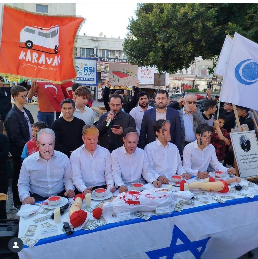 A public display outside a school and educational center in Antalya, Turkey, depicts political figures seated at a table consuming the organs and blood of Palestinian children, imagery critics say echoes historic antisemitic blood libel tropes מייצג הזוועה בטורקיה אנטליה שבו מציגים בכירים