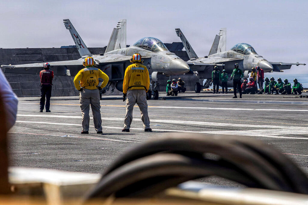 Two F/A-18F fighter jets prepare to take off from the USS Abraham Lincoln in the Arabian Sea (Photo: Daniel KIMMELMAN / US NAVY / AFP) שני מטוסי F/A-18F מתכוננים להמראה מסיפון נושאת המטוסים אברהם לינקולן בים הערבי