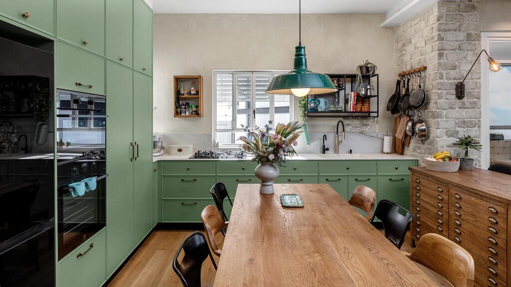 A green kitchen and restored brick wall (Photo: Shiran Carmel) שיפוץ דירה בתל אביב, עיצוב: יוליה חנדז'י
