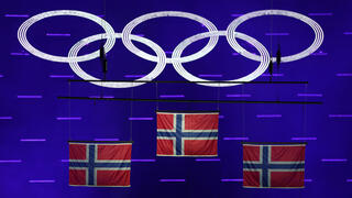 דגלי נורבגיה מונפים במהלך טקס המדליות בקרוס קאנטרי ל-50 ק"מ גברים בסגנון קלאסי