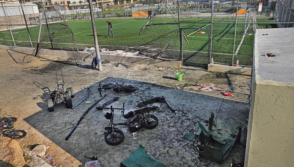 Bicycles and debris lie near a damaged fence at a soccer field in Majdal Shams after a Hezbollah rocket strike that killed 12 children, in the Golan Heights, 2024 (Photo: Efi Sharir) זירת פגיעת הטיל של חיזבאללה במג'דל שמס, שגבה את חייהם של 12 ילדים