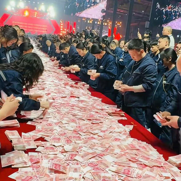 Employees of Henan Kuangshan Crane scramble to collect bundles of cash laid out on banquet tables during a Lunar New Year party on Feb. 13, as part of a multi-million-dollar giveaway to about 7,000 workers חברה סינית הניחה כסף ואמרה לעובדים קחו כמה שתוכלו
