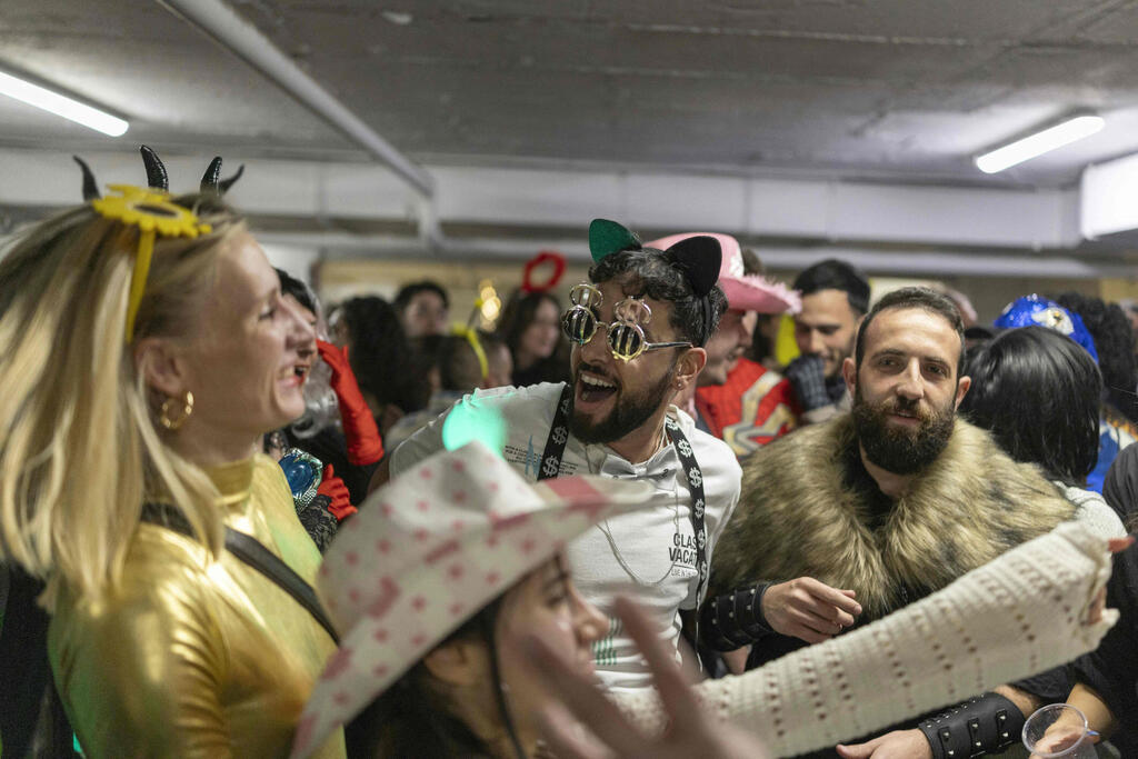A party in a Tel Aviv shelter during last Purim (Photo: AFP) ישראלים בתחפושות בחניון המתפקד כמקלט בתל אביב