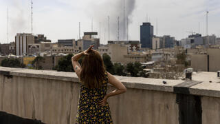 אישה צופה בתקיפה ב טהרן איראן