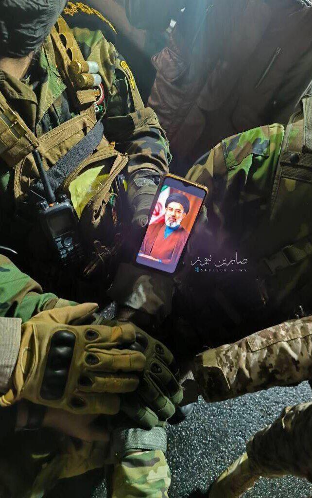 A member of an Iran-backed Iraqi militia holds a portrait of Iran's new supreme leader, Mojtaba Khamenei המיליציות הפרו איראניות בעיראק עם הכיתוב: "מהשטח- לפקודתך חמינאי"