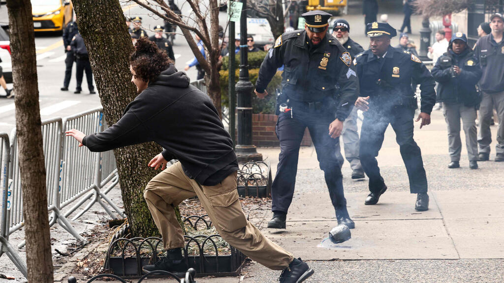 A left-wing activist flees after throwing a homemade explosive device toward police during a protest against alleged "Islamification" in front of Gracie Mansion, New York mayor Zohran Mamdani's official residence
