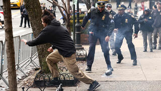 A left-wing activist flees after throwing a homemade explosive device toward police during a protest against alleged "Islamification" in front of Gracie Mansion, New York mayor Zohran Mamdani's official residence