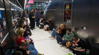 תופסים מחסה בשעת אזעקה במהלך ימי שאגת הארי בתחנת הרכבת הקלה רמת גן