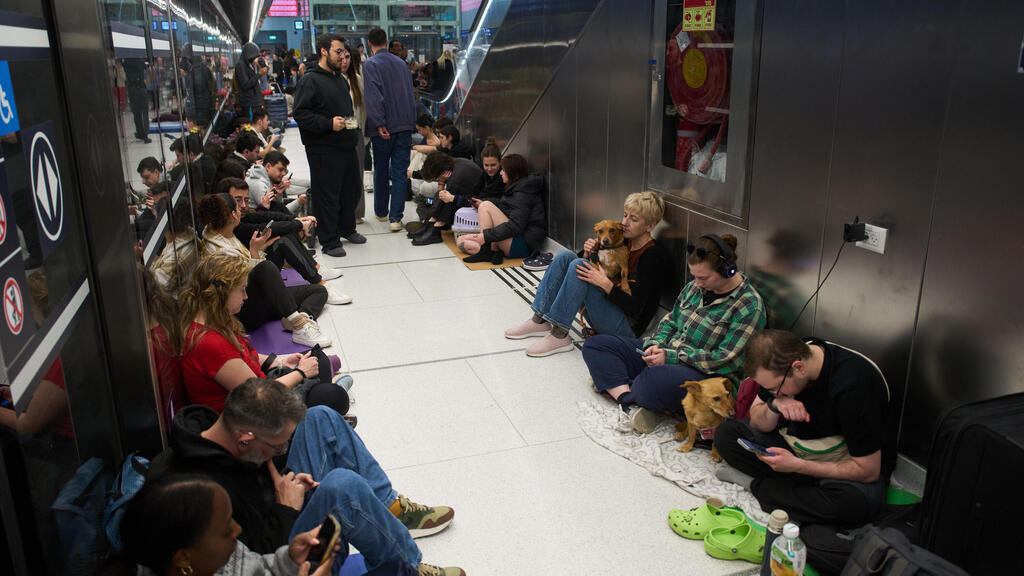 תופסים מחסה בשעת אזעקה במהלך ימי שאגת הארי בתחנת הרכבת הקלה רמת גן